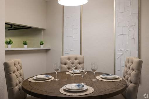 A dining table set with plates and glasses is ready for a meal.