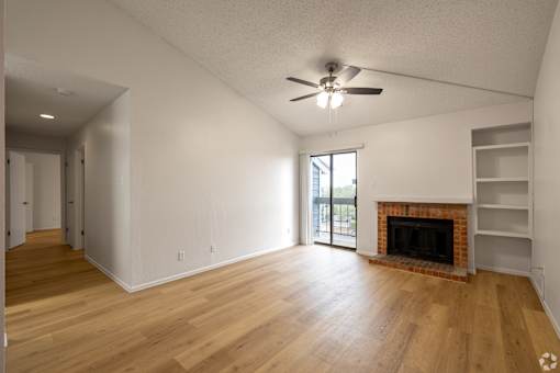 A room with a fireplace and a ceiling fan.