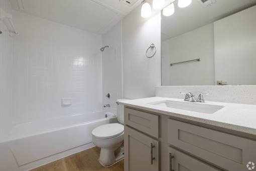 A white toilet sits in a bathroom next to a sink.