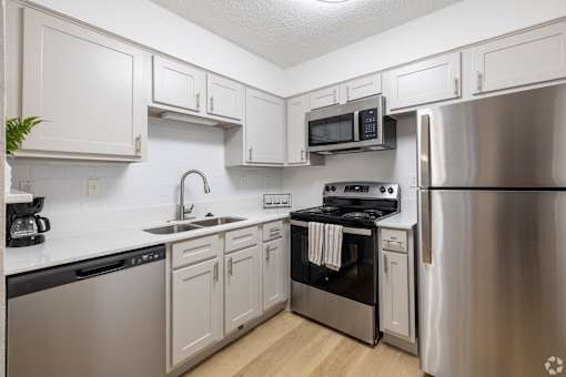 A kitchen with white cabinets and stainless steel appliances.