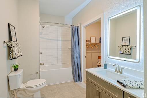 A white toilet sits next to a white sink in a bathroom at The Virginia Apartments , Seguin, TX, 78155