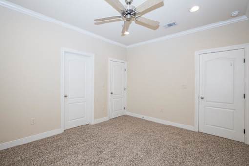 A room with a ceiling fan and four doors at Logan Ridge Apartments, Apartments, San Marcos, TX