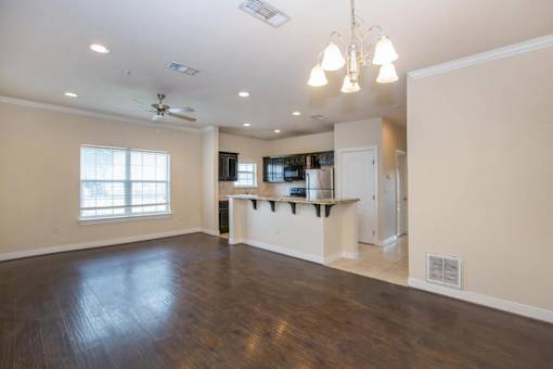 A spacious kitchen with a bar area and a ceiling fan. at Logan Ridge Apartments, Texas, 78666