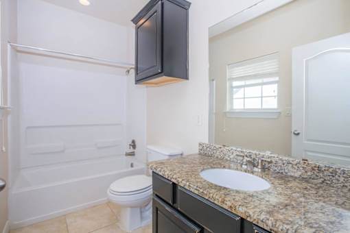 A bathroom with a toilet, sink, and bathtub at Logan Ridge Apartments, Texas