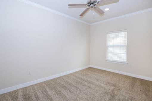 A room with a ceiling fan and a window with blinds at Logan Ridge Apartments, Texas, 78666