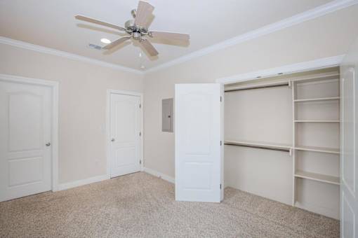 A room with a ceiling fan and four doors at Logan Ridge Apartments, San Marcos, Texas