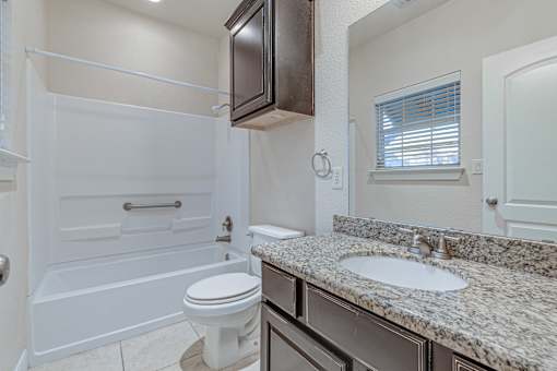 A bathroom with a white toilet and a sink at Logan Ridge Apartments, San Marcos, 78666