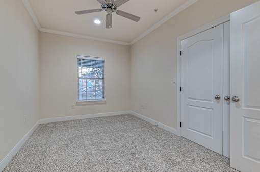 A room with a ceiling fan and a window with blinds at Logan Ridge Apartments, Apartments, San Marcos, TX
