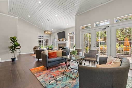 A living room with a grey couch and a rug.