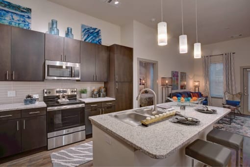a kitchen with a counter top and a sink at The Grand at Stonecreek, Texas