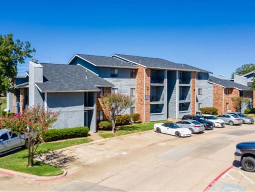 an apartment building with cars parked in front of it at Water Ridge Apartments, Irving