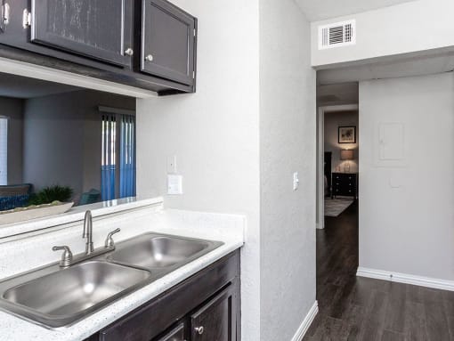 a kitchen with a sink and a window and a hallway at Water Ridge Apartments, Irving, TX 75061