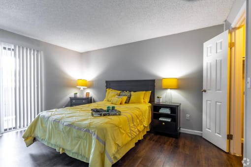 a bedroom with a yellow comforter on a bed at Water Ridge Apartments, Texas, 75061