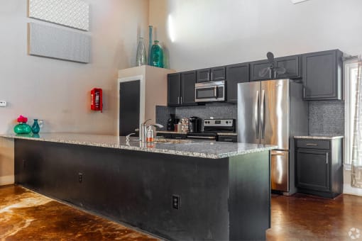 the kitchen has stainless steel appliances and a granite counter top at Water Ridge Apartments, Irving