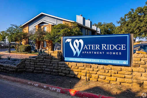 A sign for Water Ridge Apartment Homes in front of a building.