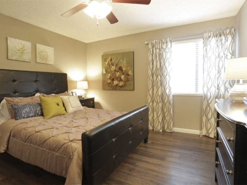 a bedroom with a bed and a ceiling fan at Water Ridge Apartments, Irving, Texas