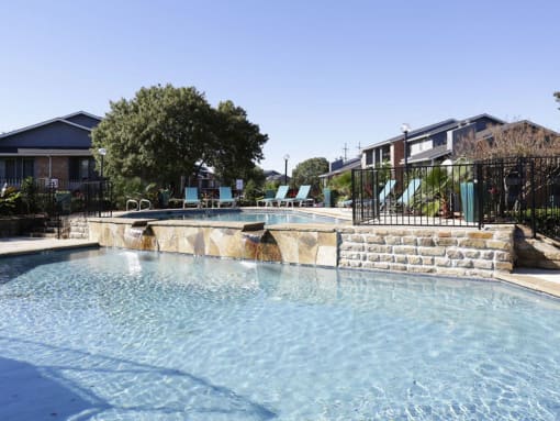 a large pool with a house in the background at Water Ridge Apartments, Irving, Texas
