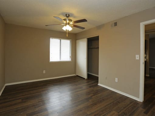 an empty living room with a ceiling fan and a door to a closet at Water Ridge Apartments, Texas, 75061