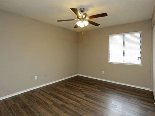 an empty room with a ceiling fan and wood floors at Water Ridge Apartments, Irving, 75061