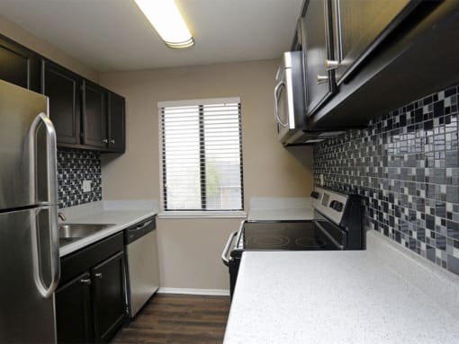 a kitchen with a stove and a window at Water Ridge Apartments, Texas