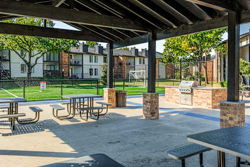 A park with tables and benches under a roof at Water Ridge Apartments , Texas