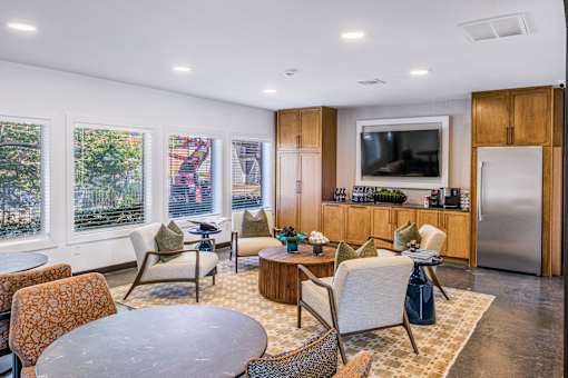 A modern living room with a television, a kitchen area, and a dining table at Water Ridge Apartments , Irving