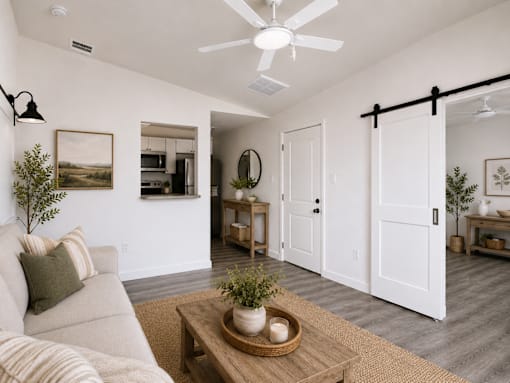 A living room with a couch, coffee table, and a ceiling fan.