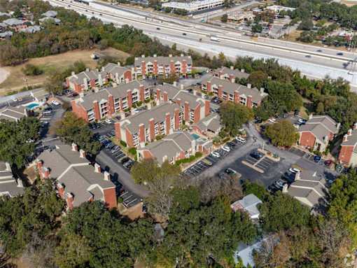 A large apartment complex with a parking lot in front.