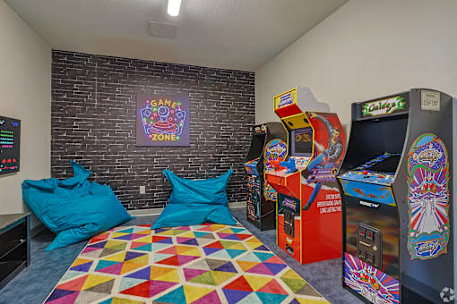 A room with a colorful carpet and a wall with a picture of a game zone. at The Virginia Apartments , Texas