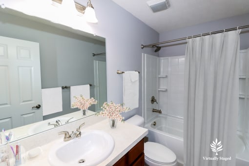 a bathroom with a white shower curtain and a white toilet next to a white sink with a