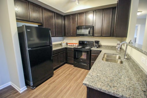 a kitchen with black appliances and a granite counter top