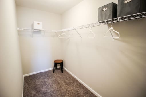 a walk in closet with a small stool in a 555 waverly unit