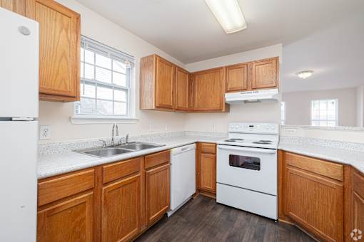 A kitchen with wooden cabinets and white appliances.