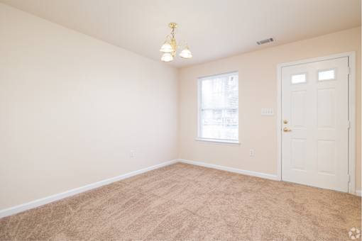 A room with a carpeted floor and a door.