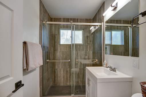 A bathroom with a walk-in shower and a white sink.