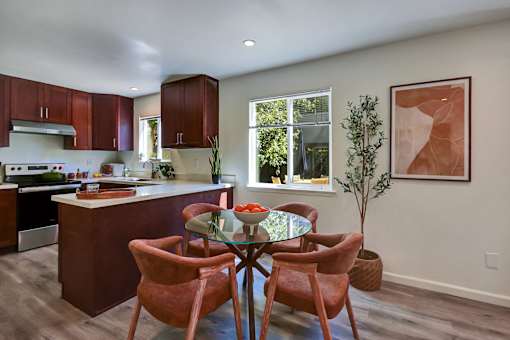 A kitchen with a table and chairs in the middle of the room.