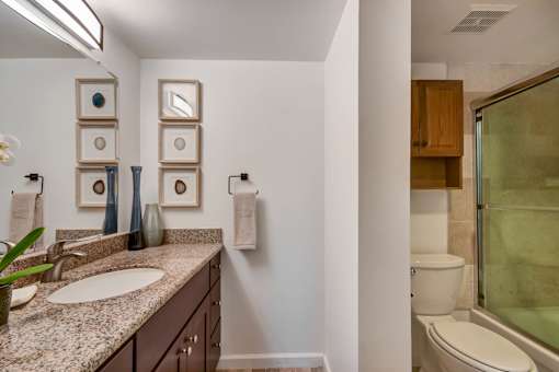 A bathroom with a sink, toilet, and a glass shower door.