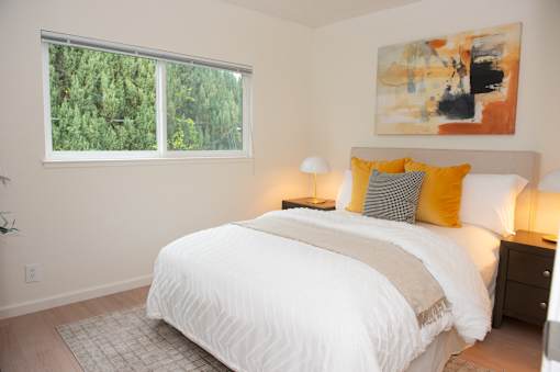A bedroom with a large bed and a painting on the wall.