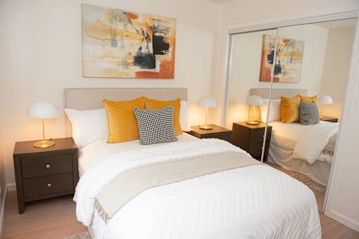 A bedroom with a large bed and a painting on the wall.