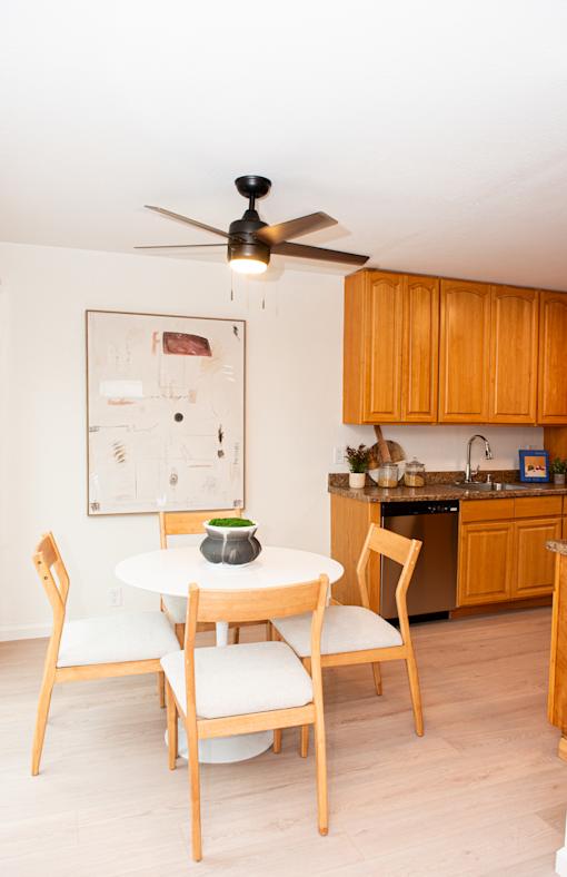 A kitchen with a table and chairs.