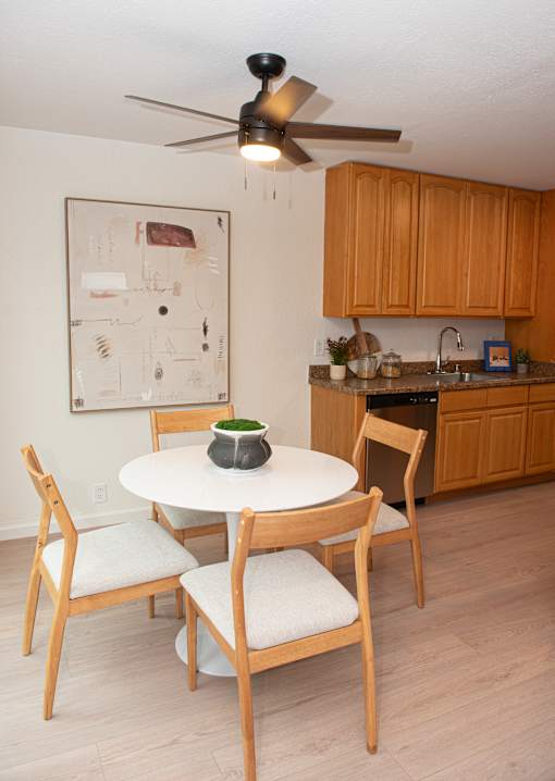 A kitchen with a table and chairs.