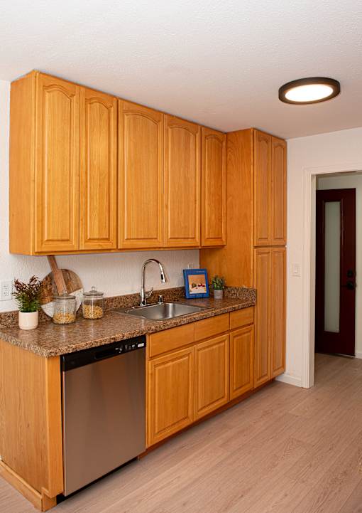 A kitchen with wooden cabinets and a granite countertop.