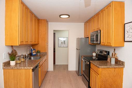 A kitchen with wooden cabinets and a black stove top oven.