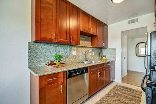 A kitchen with wooden cabinets and a granite countertop.