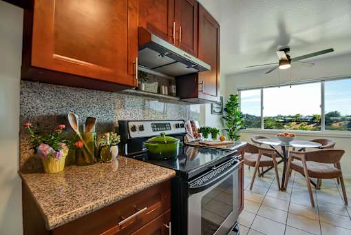 A kitchen with a stove top oven and a fan.