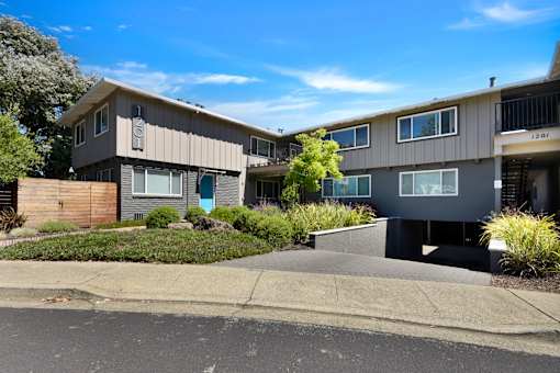 A row of modern townhouses with a clear blue sky above.