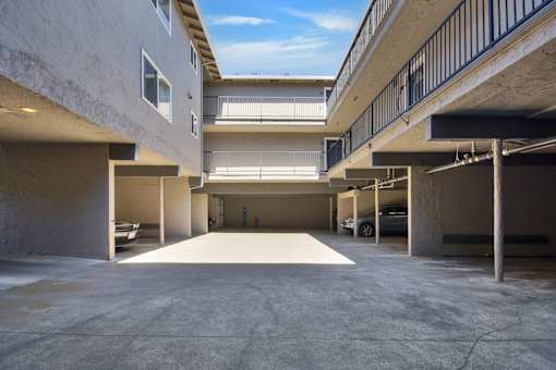 A parking garage with a clear blue sky visible through the windows.