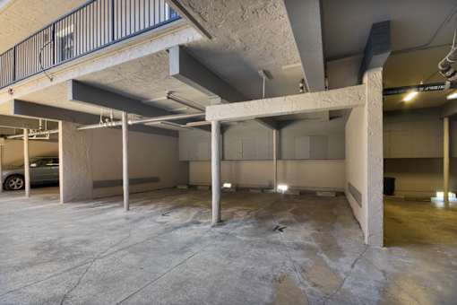 A large, empty parking garage with concrete pillars and a metal railing.