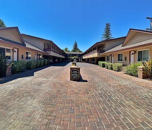 a courtyard with brick sidewalks and buildings with a fountain