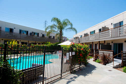 A pool surrounded by a fence with a sign on it.